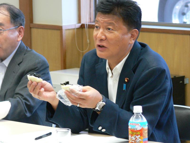 お饅頭を手に持ち熱く語る大臣