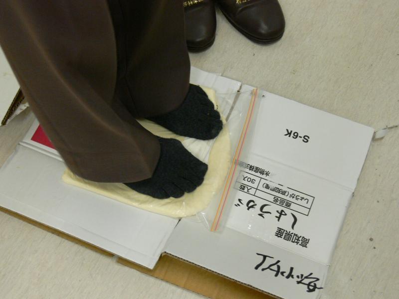 うどんを足で踏んでいる写真