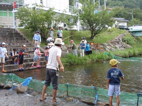 川でマス釣り体験をしている写真