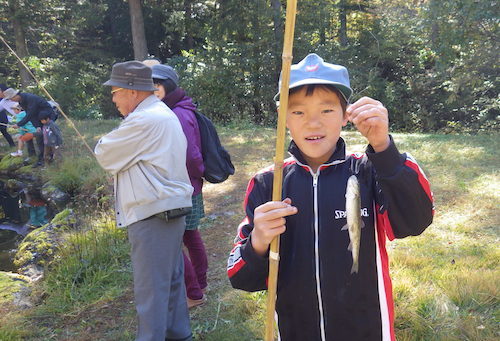 マスを釣って喜ぶ男の子